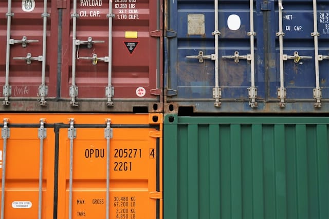 Stacked arrangement of intermodal shipping containers in various colors.